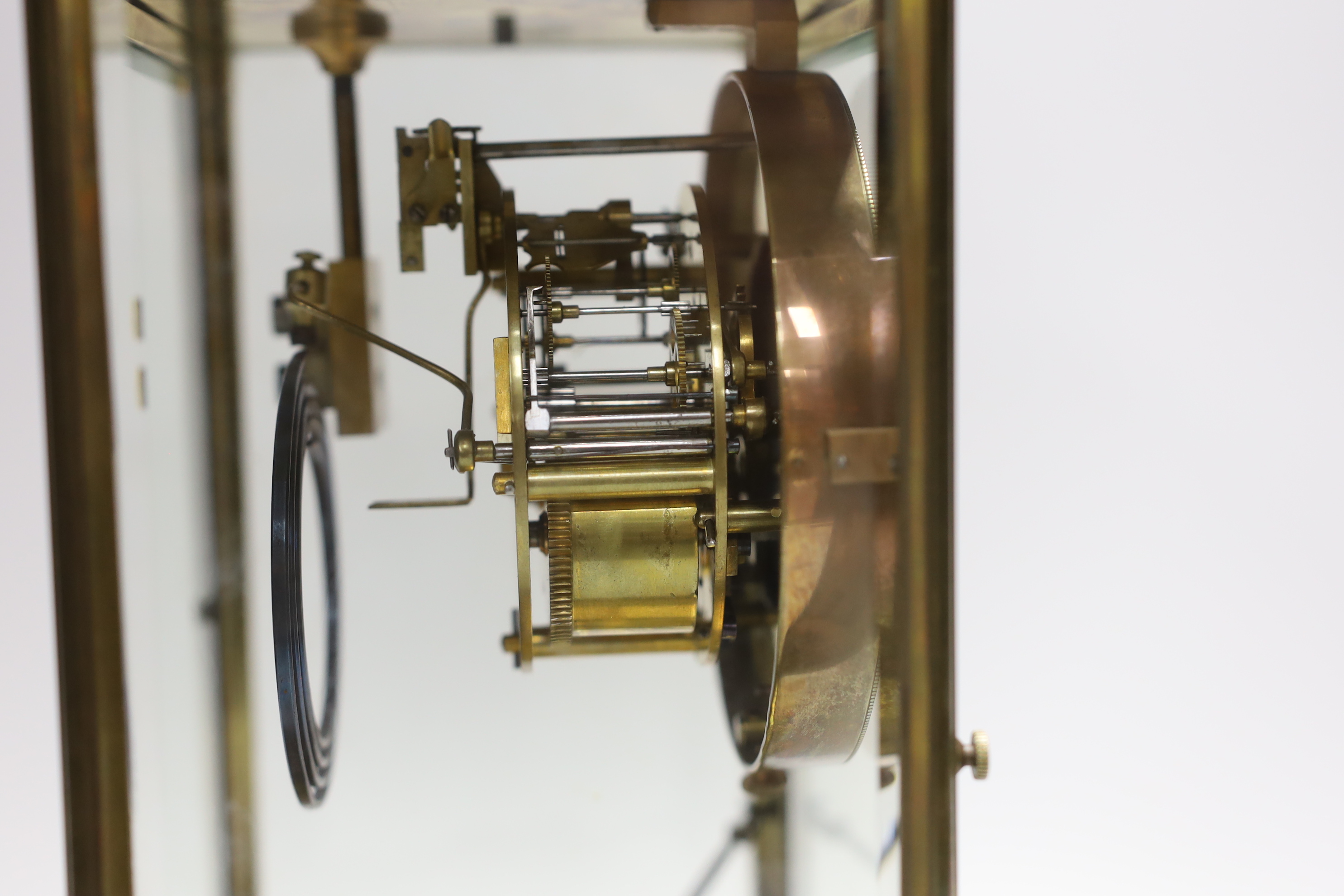 An early 20th century brass four glass clock with mercury pendulum, 28cm high